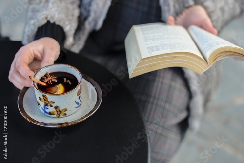 Canvas Print Woman drinks mulled wine and reads book
