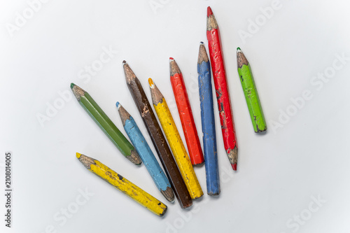 Very old used colored pencils on light background, childhood and school supplies