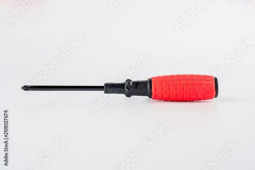 A red screwdriver against a white background; a tool for a mechanic.