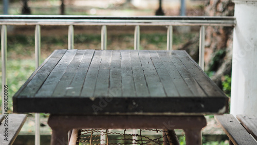 Konstfotografi photographic composition captures a front view of an empty, rustic wooden table located on an outdoor terrace or balcony