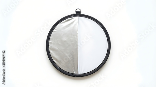 Foldable silver reflector disc for professional photography lighting. Portable round light modifier enhancing studio and outdoor shoots.