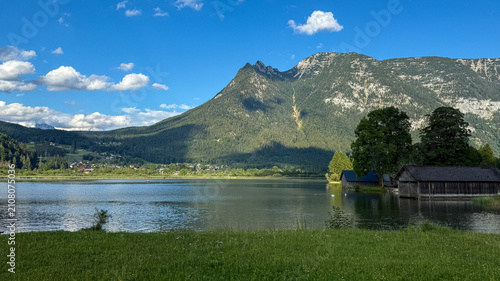 Lake Hallstatt reflects forested mountains and dramatic clouds in the Austrian Salzkammergut.