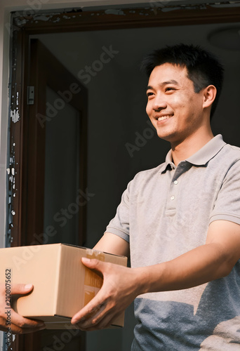 Smiling asian man receiving...