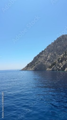 Deep blue Mediterranean sea stretching to the horizon, crystal-clear water, gentle ripples, bright sunshine, peaceful coastal landscape
