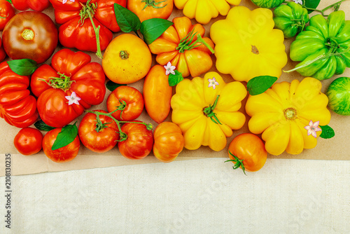 Фотография A vibrant flat lay of various homegrown heirloom tomatoes, including large ribbe