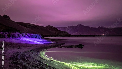 Enchanting Twilight Landscape: Illuminated Shoreline and Serene Lake Reflecting Purple Hues
