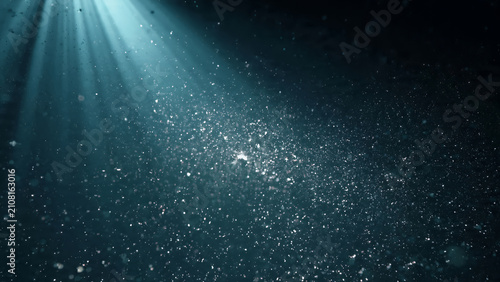 Mystical underwater light rays through dark ocean depths.