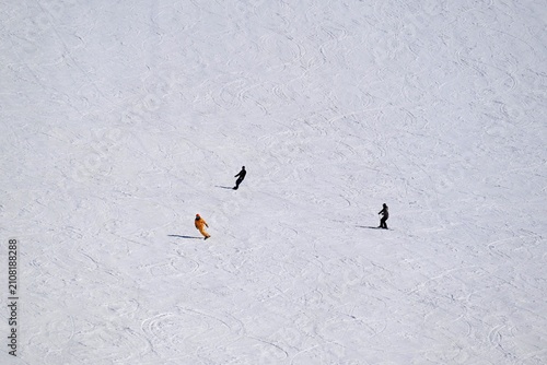 фотографія 広い雪斜面を滑るスキーヤーと冬のミニマルなウィンタースポーツ風景  
Minimal winter sports scene with skiers glidi