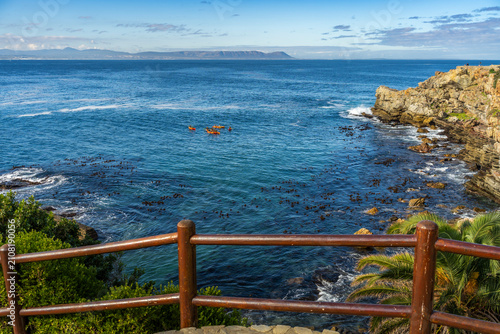 Kayakers paddle through the blue Atlantic Ocean at Gearings Point, Hermanus, on South Africa’s Whale Coast in the Overberg, Western Cape, with scenic coastal views and adventure travel appeal.