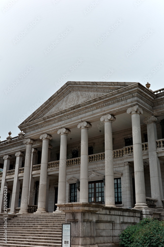 Obraz premium Ionic columns and ornate cornice of a neoclassical stone hall at Deoksugung Palace's Seokjojeon, Seoul, South Korea