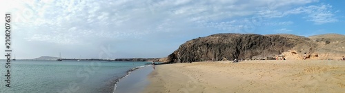 Foto Panoramic evening view of a sandy beach and volcanic headland on the Atlantic co