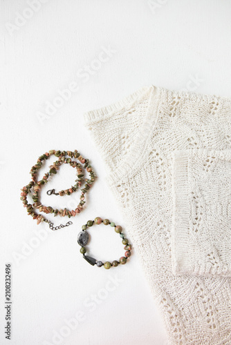 Fotografía A set of a necklace and a bracelet with jasper stones and a light-colored sweate