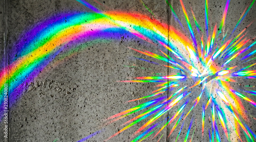 Vivid rainbow light refraction on concrete wall creating a stunning and colorful visual display with bright spectrum hues and dynamic patterns for artistic and creative inspiration