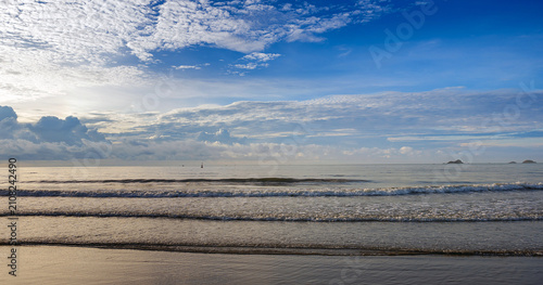 golden morning light on wet sandy beach, sunrise sidelight coastal photography, warm sunlight ocean waves tropical beach
