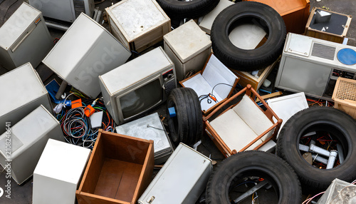 Pile of discarded household waste and junk. Old electronics and tires in a landfill dump.