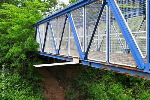 Quadro su tela Blue steel truss bridge with unexpected structural defect and improvised metal p