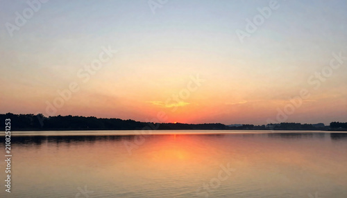 Serene sunset reflection a calm lake scene with vibrant orange and blue hues