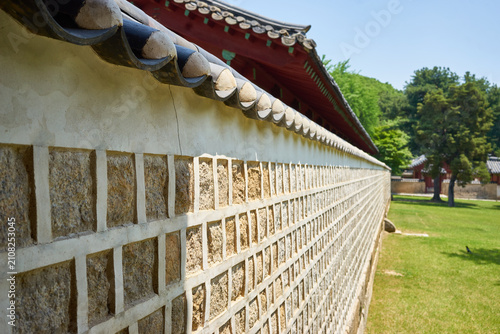 Fotografie Dynamic angled view of a traditional Asian stone barrier topped with classic dark clay ornaments
