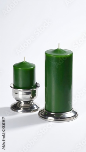 Two green pillar candles in silver holders on white background (1)