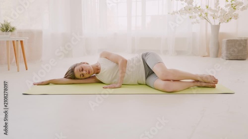 Woman doing clamshell exercise on yoga mat at home
