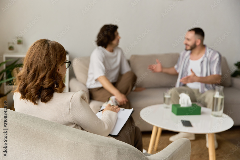 Fototapeta premium Loving gay couple shares their thoughts with a therapist in a cozy therapy room