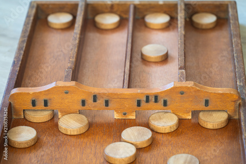 Sjoelen gameplay, classic dutch tabletop board game with wooden pucks and board called sjoelbak