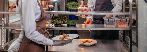 Restaurant Kitchen Staff Serving Gourmet Dish During Service