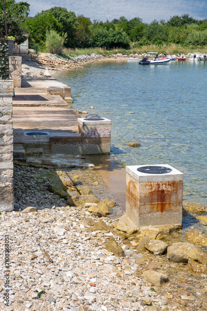 Fototapeta premium Concrete pier and pebble beach. Adriatic coast, Istria, Croatia.