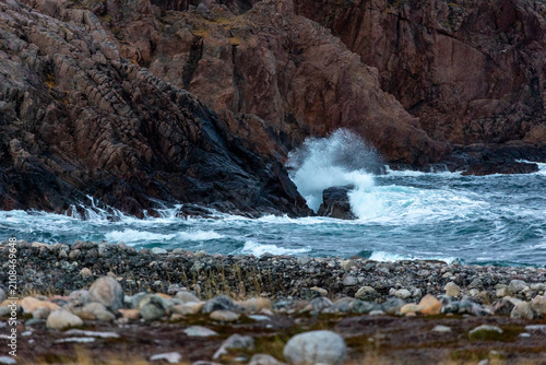 Photos White sea foam splashing as strong ocean waves hit rugged rocky shoreline