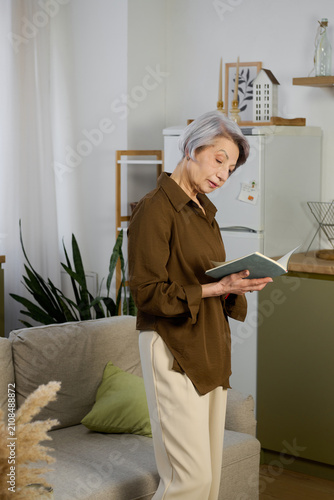 Принти на полотні Bright and airy apartment features a graceful woman absorbed in her reading
