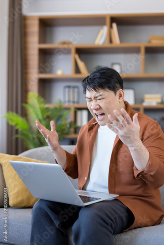 Fotografi Stressed asian man working from home, experiencing computer issues and emotional