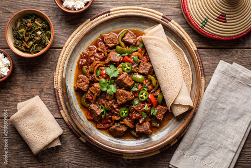 Traditional Ethiopian beef tibs served with spongy injera flatbread and spicy vegetable sauce.