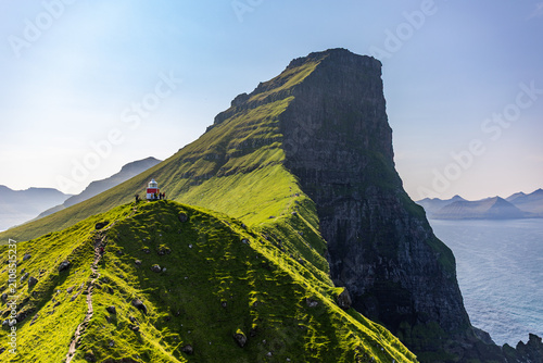 Foto Lighthouse on Green Hill Overlooking Ocean, Faroe Islands