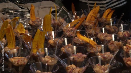 A waiter orders cups of ceviche to be served at a luxury party