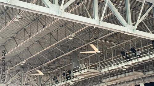 Industrial fans in the ceiling rafters of a large event venue structure background