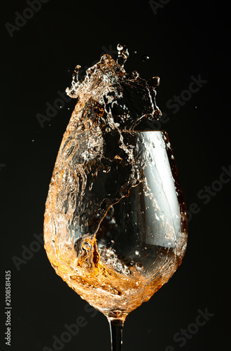 An image of white wine being splashed into a glass.