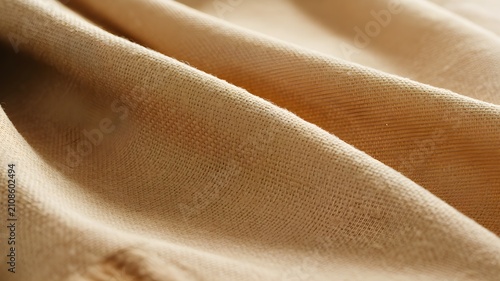 Closeup of beige linen fabric texture with soft folds