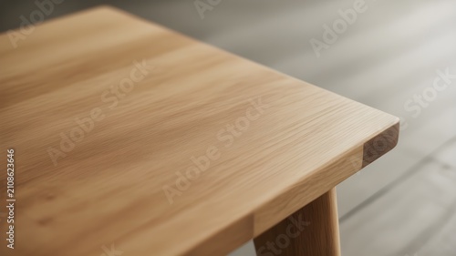Closeup of a light oak wood table surface with visible grain texture and a smooth finish, showcasing natural wood patterns and craftsmanship in a bright room