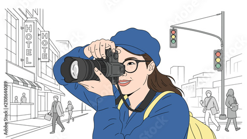 Smiling female photographer with a blue hat and glasses takes a professional photo on a busy city street with traffic and hotels.