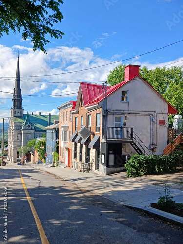 Cobblestone street in historic Old Quebec. Stone house facades and church. Rue de Claire-Fontaine in Quebec City. European architecture and construction.
