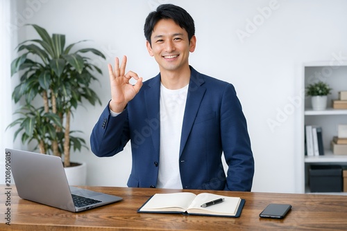 ビジネスで成功しOKサインする自信ある日本人男性の笑顔