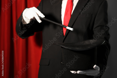 Canvas Print Magician showing trick with wand and top hat on stage, closeup