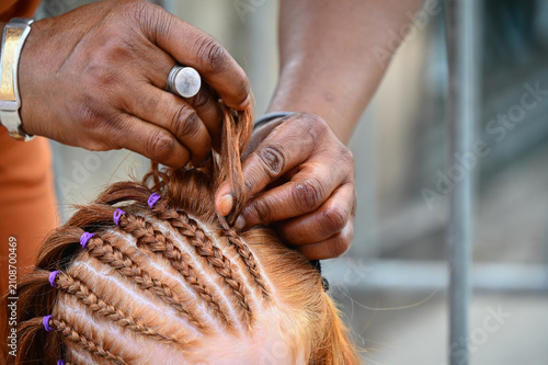 Foto Une femme fait des tresses dans les cheveux roux d'une femme