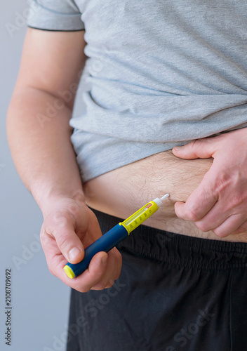 person uses insulin pen for glucose control at hom