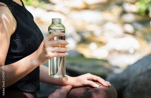 Schilderij op canvas Fresh clean drinking water in a reusable glass bottle during an outdoor escape
