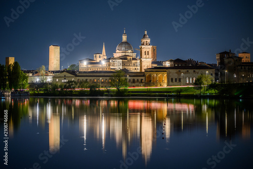 Fotografie Illuminated night skyline of Mantua with domes and towers reflected in the lake,