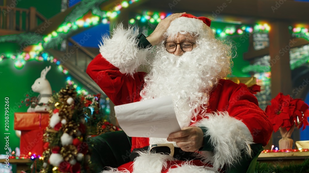 Fototapeta premium Santa Claus shakes his head in disapproval after seeing exaggerated wish lists from children asking for expensive Christmas gifts.