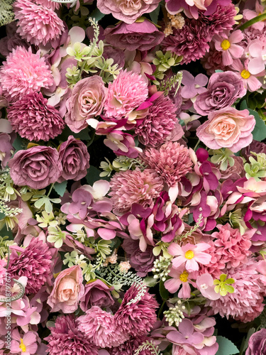 Eastleigh Hampshire UK. 18.07.2026. A dense wall of artificial flowers in shades of pink and deep purple, interspersed with delicate ferns