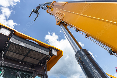 Photography Telehandler telescopic boom arm raised above yellow cabin roof