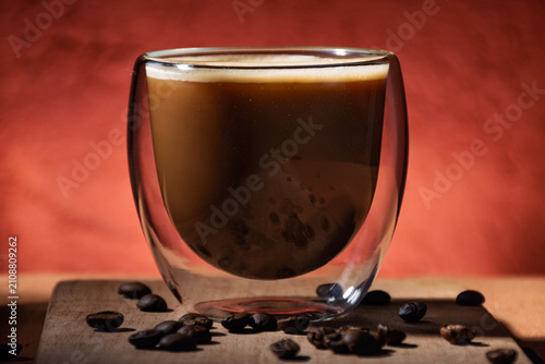 Close-up of a glass cup with coffee and milk.